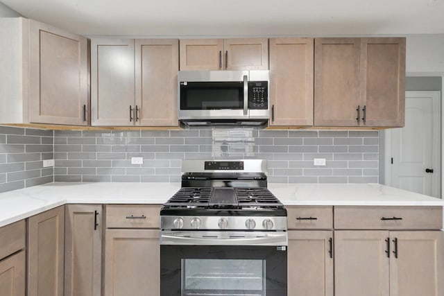 kitchen featuring stainless steel appliances, backsplash, and light stone countertops