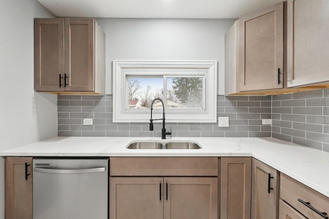 kitchen featuring stainless steel dishwasher, backsplash, a sink, and light stone countertops