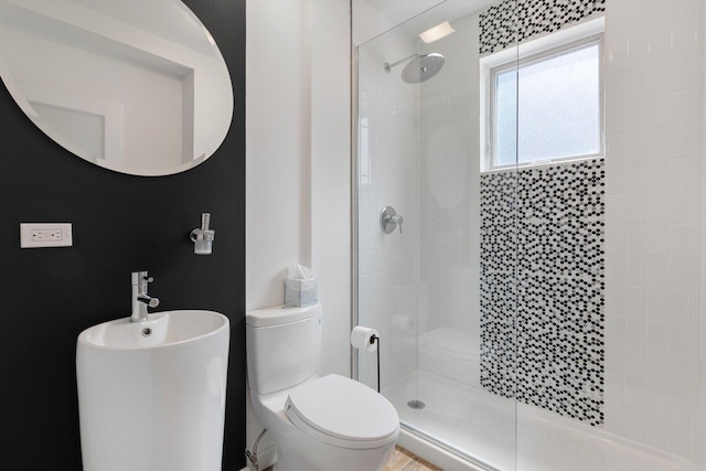 bathroom featuring tiled shower and toilet