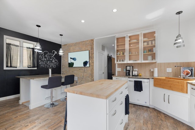 kitchen with white cabinets, white dishwasher, and a kitchen island