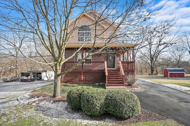 view of front of house with a porch and a storage unit