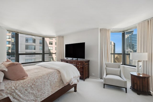 bedroom featuring light colored carpet and multiple windows