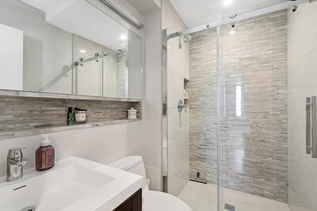 bathroom with vanity, toilet, and a shower with shower door