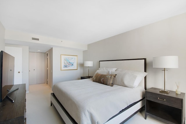 bedroom with light carpet and a closet