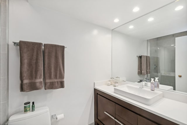 bathroom featuring walk in shower, vanity, and toilet