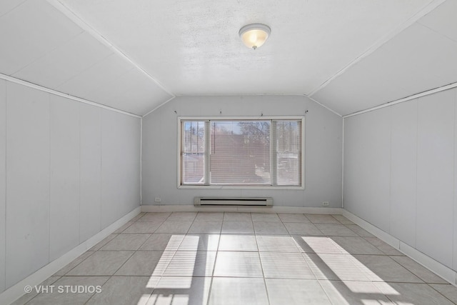 additional living space featuring a baseboard heating unit, vaulted ceiling, a textured ceiling, and light tile patterned flooring