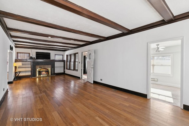 unfurnished living room with beamed ceiling and wood-type flooring