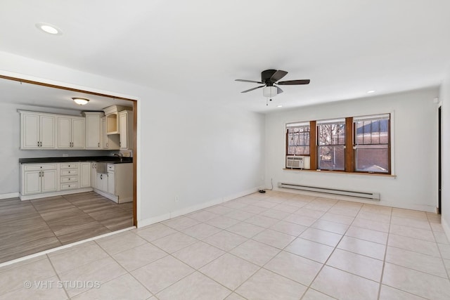 interior space featuring ceiling fan, light tile patterned floors, and a baseboard heating unit