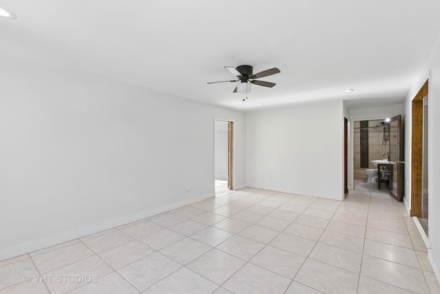 tiled empty room featuring ceiling fan