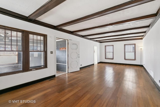 spare room with beamed ceiling and dark hardwood / wood-style floors