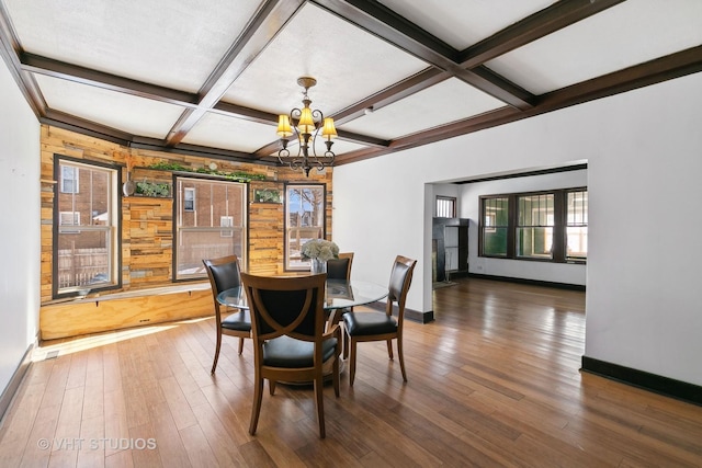 dining room featuring coffered ceiling, dark hardwood / wood-style flooring, beamed ceiling, and an inviting chandelier