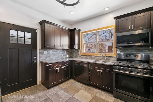 kitchen featuring sink, decorative backsplash, dark brown cabinetry, stainless steel appliances, and light stone countertops