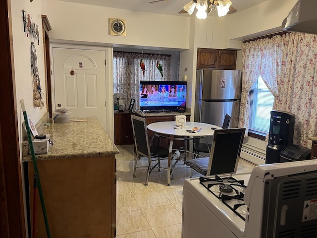 kitchen featuring stainless steel fridge, stove, dark brown cabinets, ceiling fan, and light tile patterned floors