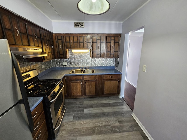 kitchen with sink, appliances with stainless steel finishes, tasteful backsplash, dark hardwood / wood-style flooring, and dark brown cabinetry