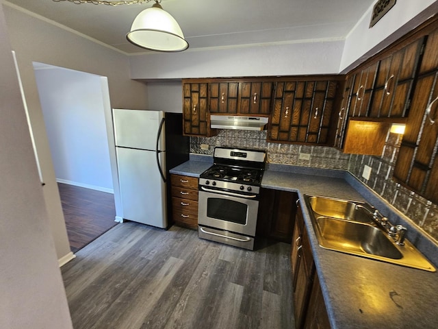 kitchen with white refrigerator, dark hardwood / wood-style flooring, stainless steel range with gas cooktop, and sink