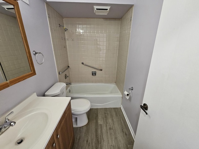 full bathroom with hardwood / wood-style floors, vanity, toilet, and tiled shower / bath