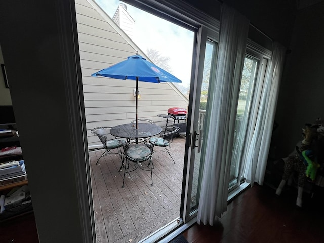 doorway to outside with dark hardwood / wood-style flooring and wood walls