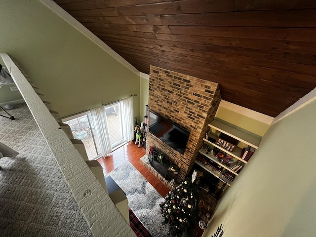 living room featuring hardwood / wood-style flooring, lofted ceiling, wood ceiling, and a brick fireplace