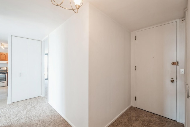 corridor with carpet flooring and a chandelier