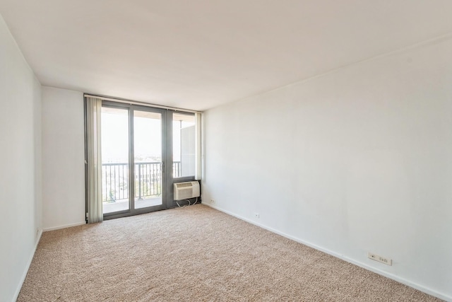 spare room with carpet, expansive windows, and a wall unit AC