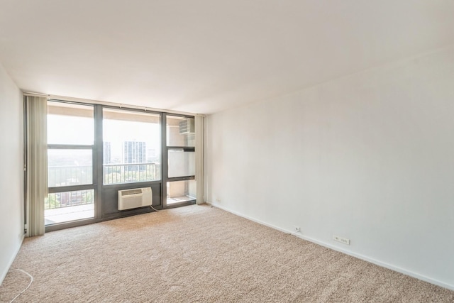 carpeted spare room with a wall of windows and a wall unit AC