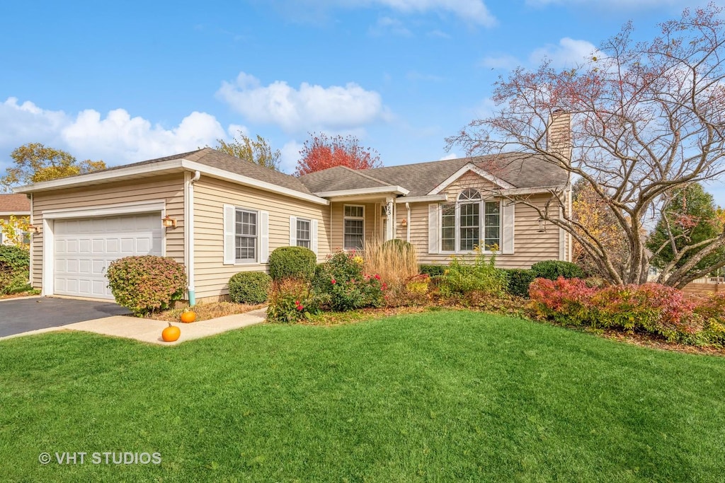 ranch-style house featuring a garage and a front yard