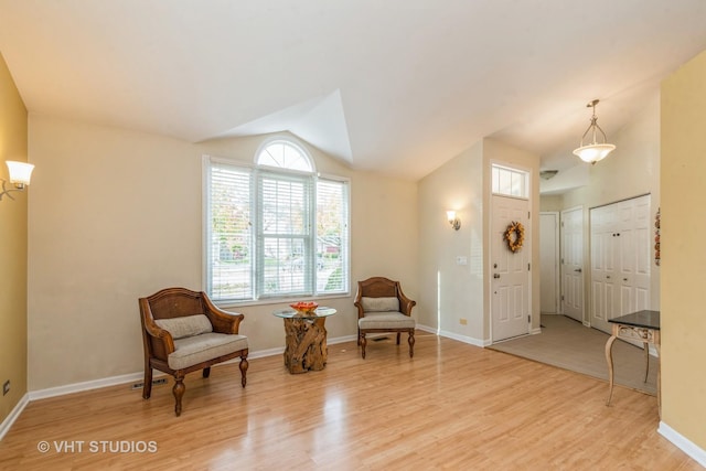 living area featuring light hardwood / wood-style floors and vaulted ceiling