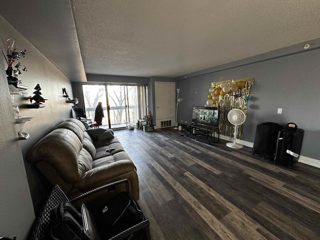 living room featuring a textured ceiling and dark wood-type flooring