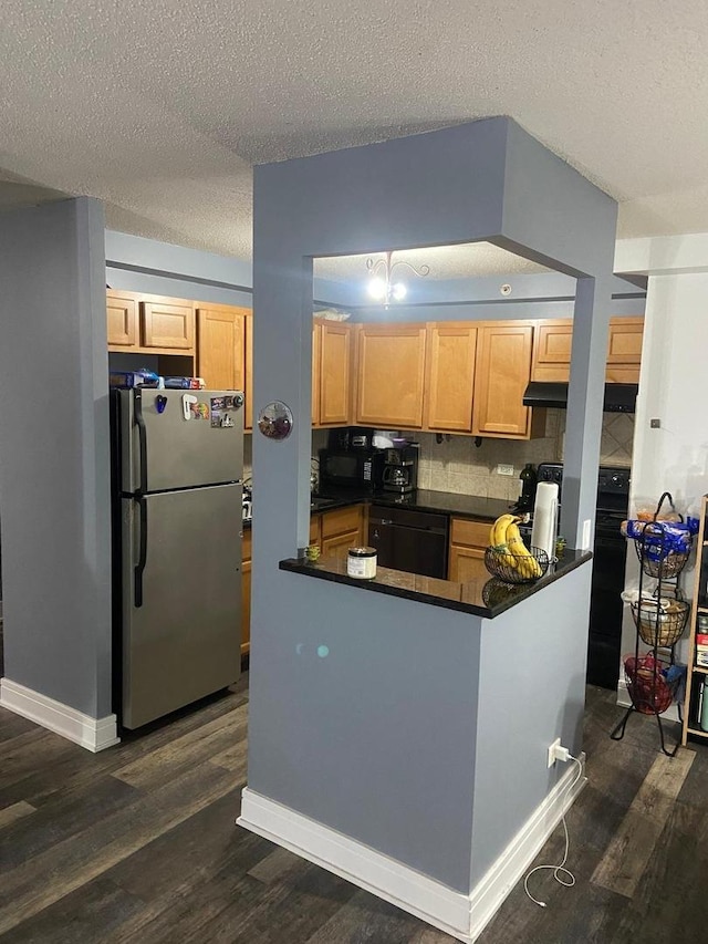 kitchen with stainless steel refrigerator, dishwasher, dark hardwood / wood-style flooring, kitchen peninsula, and a textured ceiling