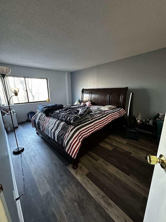 bedroom with dark hardwood / wood-style flooring and a textured ceiling