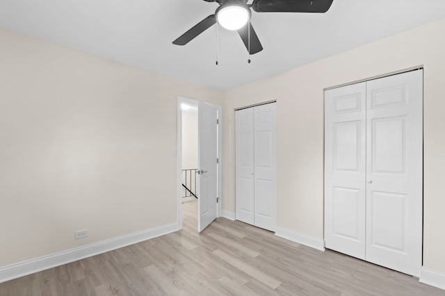 unfurnished bedroom with two closets, light hardwood / wood-style flooring, and ceiling fan