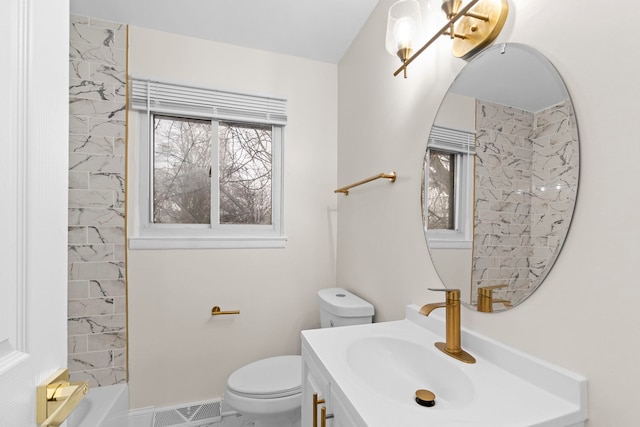 bathroom featuring vanity, toilet, and a tub