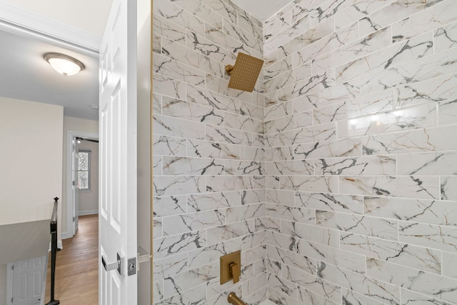 bathroom with hardwood / wood-style floors and tiled shower / bath