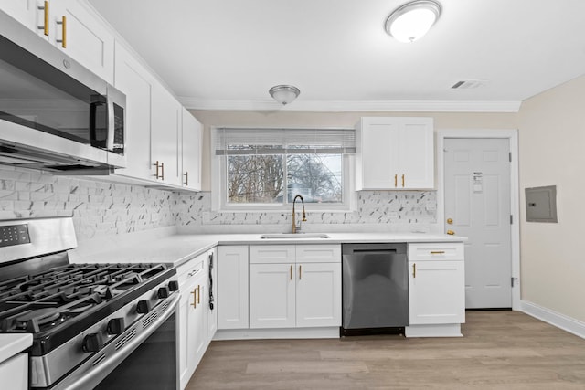 kitchen with sink, stainless steel appliances, light hardwood / wood-style flooring, electric panel, and white cabinets