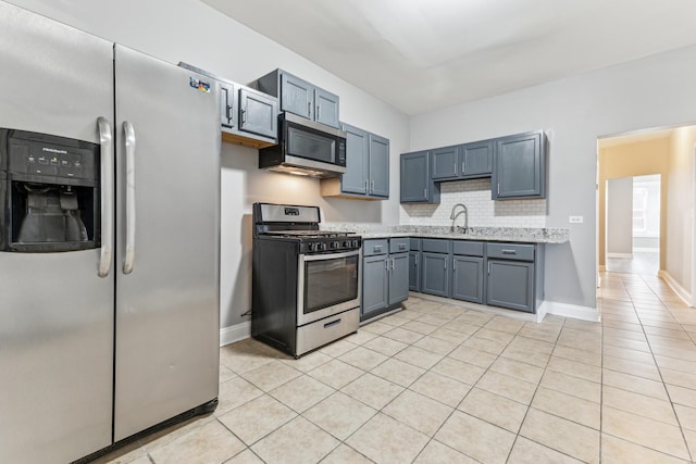 kitchen featuring decorative backsplash, light tile patterned floors, sink, and appliances with stainless steel finishes