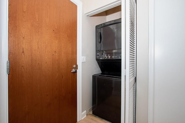 laundry room featuring stacked washer / drying machine