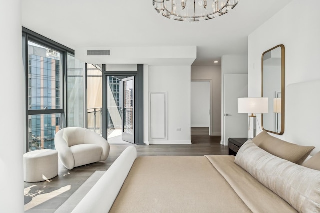 bedroom with a notable chandelier, floor to ceiling windows, access to exterior, and wood-type flooring