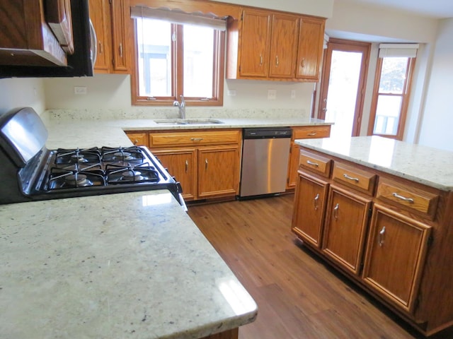 kitchen featuring light stone counters, stainless steel dishwasher, sink, black gas stove, and dark hardwood / wood-style floors