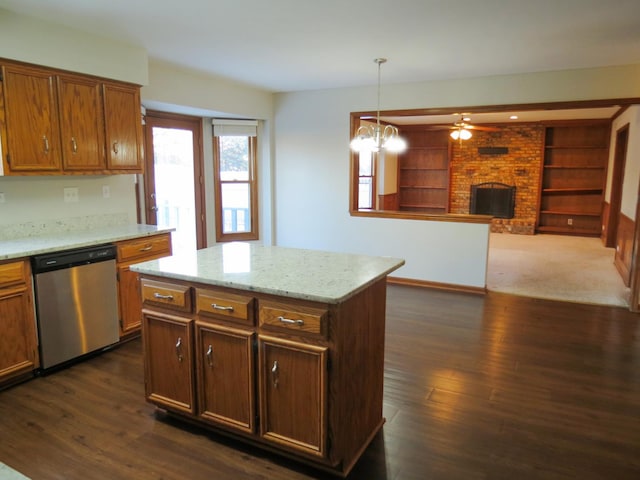 kitchen with a brick fireplace, dark wood-type flooring, pendant lighting, dishwasher, and a center island