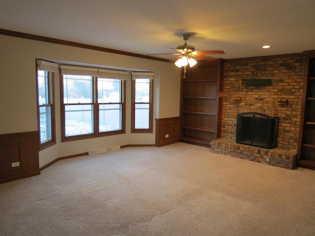 unfurnished living room featuring ceiling fan, crown molding, and light carpet