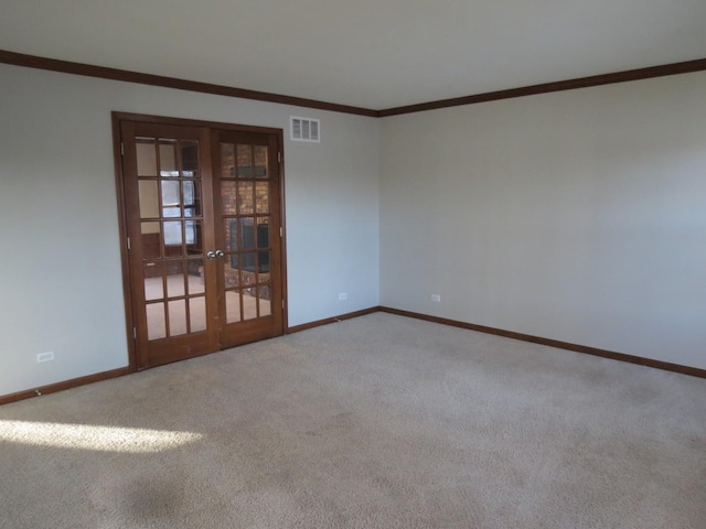 carpeted spare room featuring ornamental molding and french doors