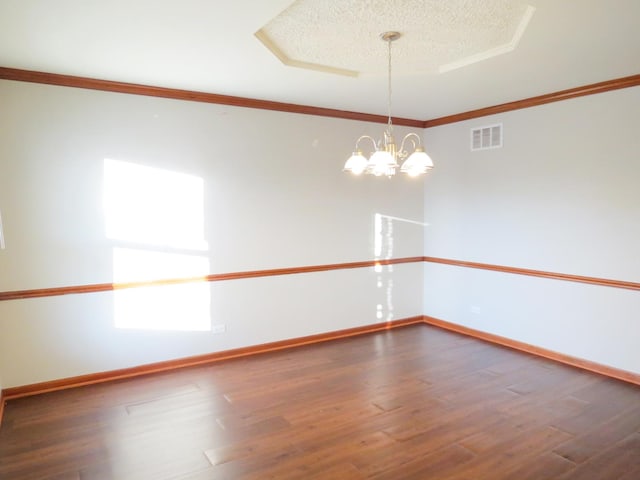 unfurnished room with dark hardwood / wood-style floors, ornamental molding, a textured ceiling, and an inviting chandelier