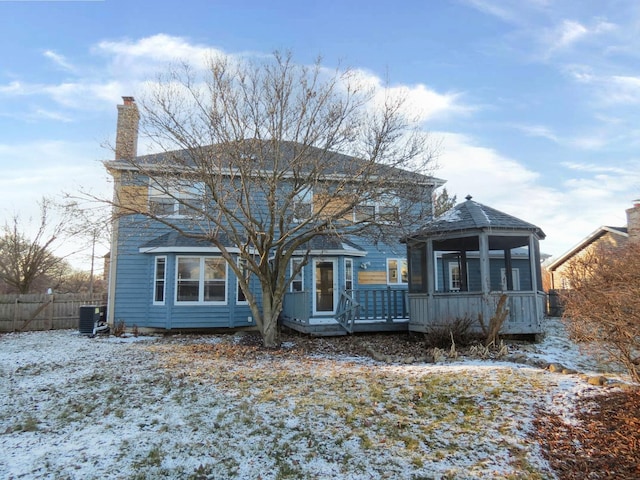 view of front of home with central AC unit, a sunroom, and a deck