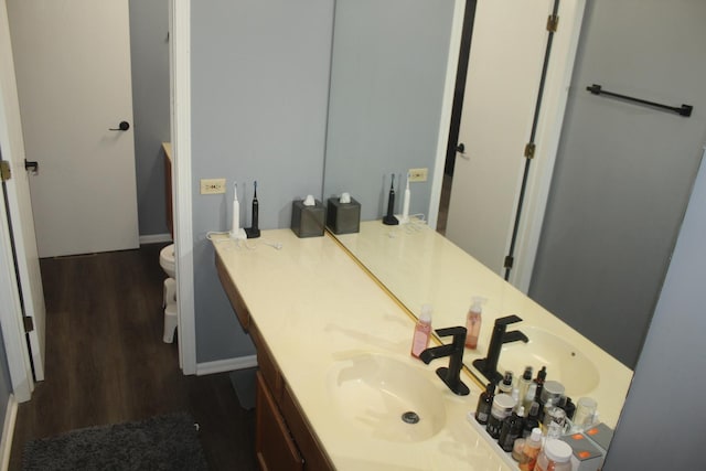 bathroom featuring wood-type flooring, vanity, and toilet