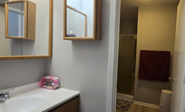 bathroom featuring vanity, wood-type flooring, and walk in shower