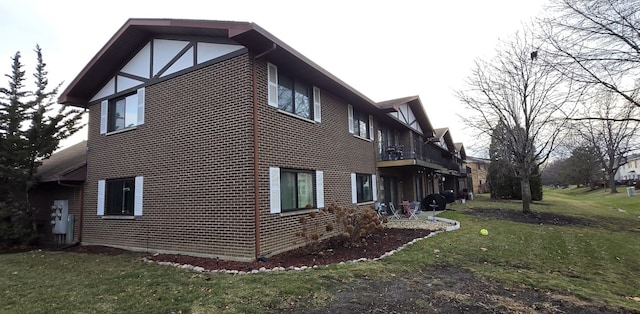 view of side of property with a yard and a balcony