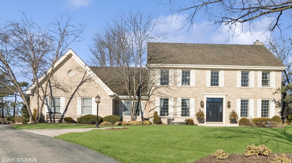 colonial-style house with a front lawn