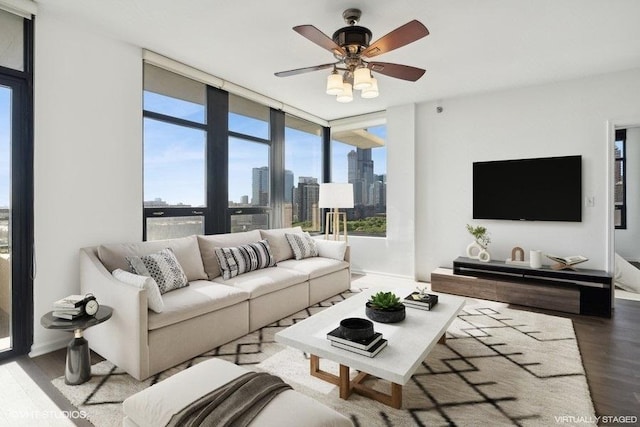 living room with a wall of windows, ceiling fan, and hardwood / wood-style flooring