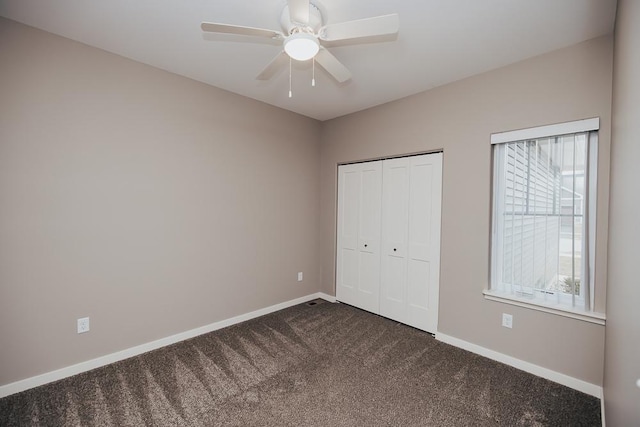 unfurnished bedroom featuring ceiling fan and dark carpet