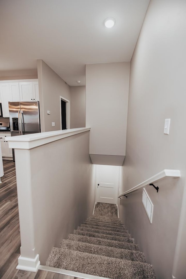 stairs featuring hardwood / wood-style floors